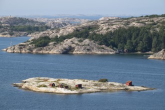 Archipelago landscape with rocks and an offshore archipelago island with falun red woodsheds,