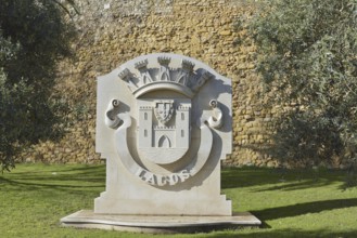 Coat of arms of the city of Lagos in front of the city wall, Lagos, Algarve, Portugal