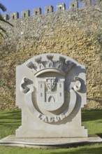 Coat of arms of the city of Lagos in front of the city wall, Lagos, Algarve, Portugal