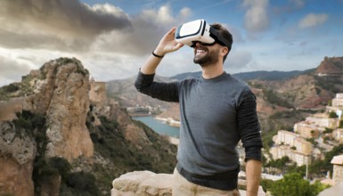 A man wearing a VR headset is standing on a rocky hillside, looking out over a beautiful landscape.