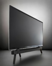 A black flat screen television is turned off. The stand is black and has a black base, AI generated