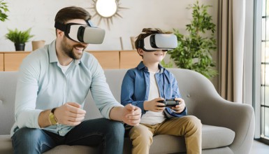 A man and a boy are sitting on a couch playing a video game. The boy is wearing a blue shirt and