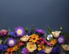 A variety of colorful wildflowers flourish on a hillside against a blurred mountainous backdrop.