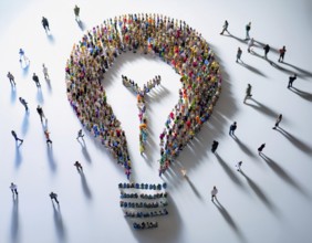Large group of individuals assembled to form the shape of a lightbulb, symbolizing ideas,
