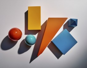 Vividly colored geometric shapes, including spheres and pyramids, artfully arranged on a surface.
