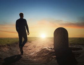 A silhouette of a lone figure walking off a gravestone, The scene evokes Resurrection thoughts