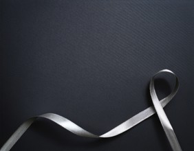 A beautifully wrapped gift box adorned with colorful satin ribbons forming a bow, contrasting