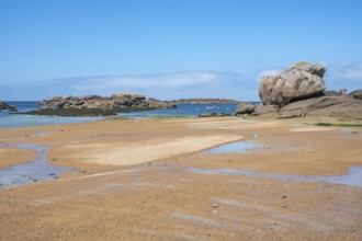 Spectacular pink granite rocks, sculpted by wind and sea, pile up on the beach of the Cote de