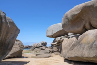 Spectacular pink granite rocks, sculpted by wind and sea, pile up on the beach of the Cote de