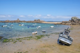 On the harbour beach of Tregastel on the Cote de Granit Rose, small boats lie on the light sand at