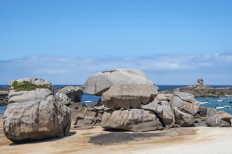 Spectacular pink granite rocks, sculpted by wind and sea, pile up on the beach of the Cote de