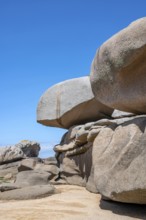 Spectacular pink granite rocks, sculpted by wind and sea, pile up on the beach of the Cote de