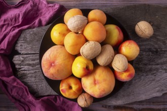 Yellow fruits - peaches, apricots, plums on a wooden background