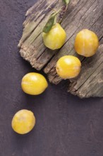 Yellow plums on a wooden board