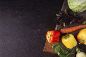Cabbage, peppers, zucchini, greens, carrots on a wooden board space for text