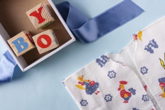 Clothes for a newborn boy and wooden cubes with letters Boy