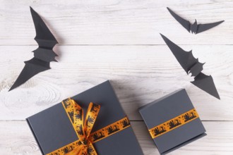 A pair of gray boxes tied with an orange ribbon, with drawings on the theme of Halloween copy space