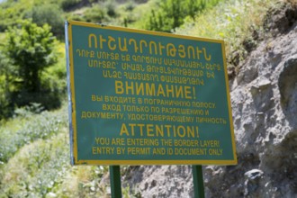 A multilingual warning sign regulating access to the border zone, sign in front of a military post