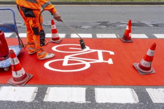 Application of red road surfacing on a cycle lane, inner-city road, so-called cold plastic