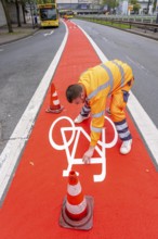 Application of red road surfacing on a cycle lane, inner-city road, so-called cold plastic