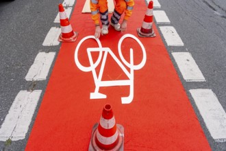 Application of red road surfacing on a cycle lane, inner-city road, so-called cold plastic