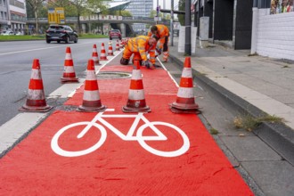 Application of red road surfacing on a cycle lane, inner-city road, so-called cold plastic