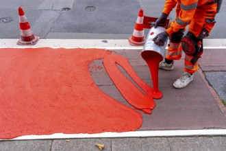 Application of red road surfacing on a cycle lane, inner-city road, so-called cold plastic