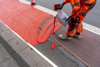 Application of red road surfacing on a cycle lane, inner-city road, so-called cold plastic