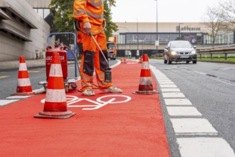 Application of red road surfacing on a cycle lane, inner-city road, so-called cold plastic
