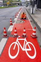 Application of red road surfacing on a cycle lane, inner-city road, so-called cold plastic