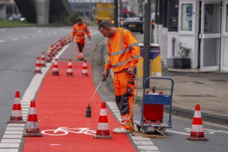 Application of red road surfacing on a cycle lane, inner-city road, so-called cold plastic