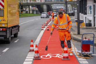 Application of red road surfacing on a cycle lane, inner-city road, so-called cold plastic