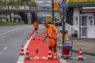 Application of red road surfacing on a cycle lane, inner-city road, so-called cold plastic