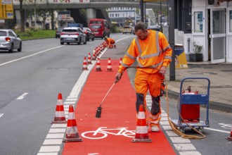 Application of red road surfacing on a cycle lane, inner-city road, so-called cold plastic