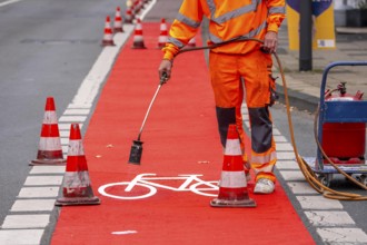 Application of red road surfacing on a cycle lane, inner-city road, so-called cold plastic