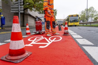 Application of red road surfacing on a cycle lane, inner-city road, so-called cold plastic