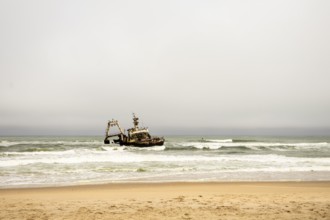The Zeila shipwreck off Namibia's Skeleton Coast, rusting in the Atlantic surf under cloudy skies
