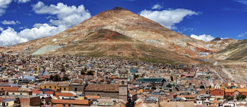 Expansive view of a city in front of an impressive mountain and blue sky, The silver mountain Cerro