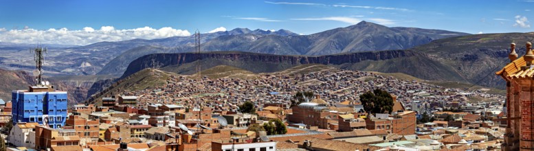 Far-reaching panorama with cityscape and surrounding mountains under a clear sky, view over the