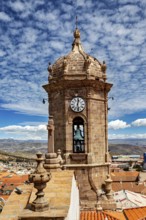 View of a historic bell tower with clock in front of a clear sky over an old town, The churches of