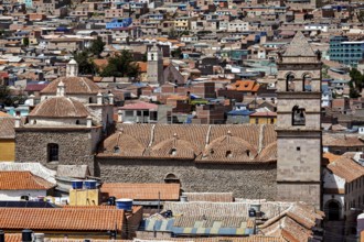 Densely built-up city scene with brick towers and colonial architecture in the foreground, The