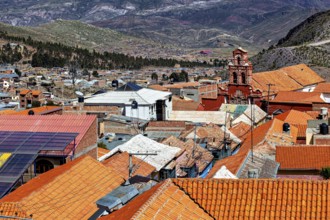 Roofs of a city with a church in the background, embedded in a mountainous landscape, view over the