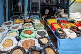 Colourful spices and grains in sacks on a market stall, variety and aromas create a lively