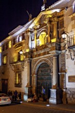 Illuminated historical building at night with people nearby, The churches of the city of Potosi in