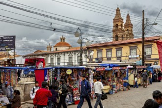 Lively town square with market stalls in front of a baroque church and under a cloudy sky, Small