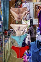 Colourful underwear hanging on chains in a lively market shop, selling women's panties in the