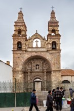 Historic church with two towers under a cloudy sky, surrounded by people, The churches of the city