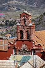 Red building with a detailed bell tower in front of a mountainous landscape, The churches of the