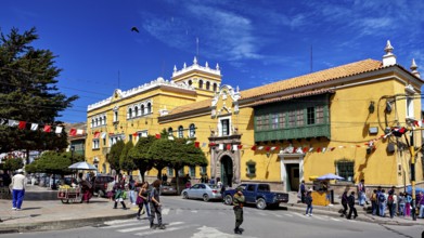 Colonial-style building with market scene and decorative flags, The streets of the historic centre