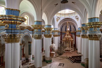 Magnificent church interior with richly decorated arches and altars in blue, white and gold, inside